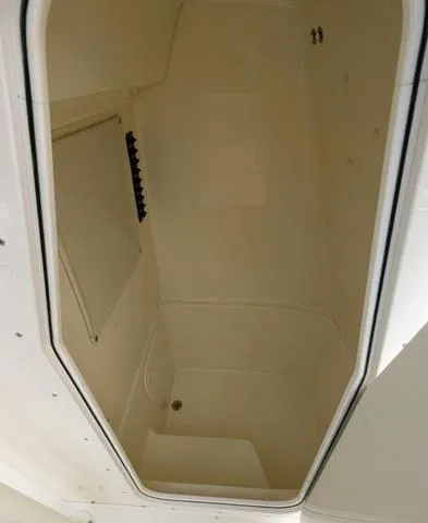 Slide: The Image of 2025 Cobia 220 CC boat anchor storage compartment with coiled rope and anchor chain. - 27