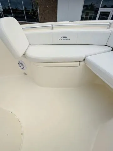 Slide: The Image of 2025 Cobia 220 CC boat interior with white seating and speaker. - 34