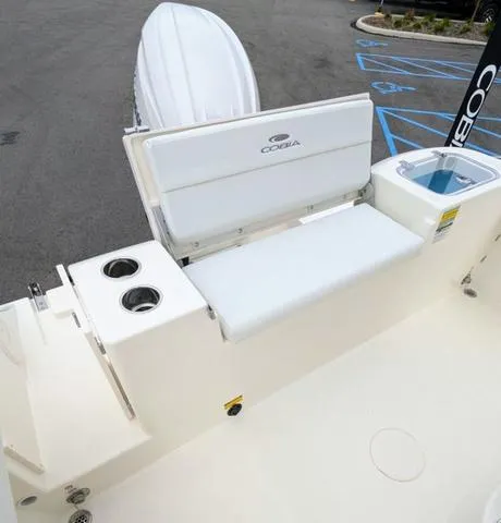 Slide: The Image of 2025 Cobia 220 CC boat with Yamaha engine, featuring a clean deck and storage compartments. - 43