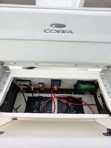 Slide: The Image of Livewell on 2025 Cobia 220 CC boat, featuring a secure lid and drain plug. - 45