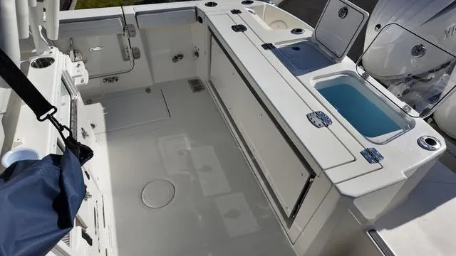 Slide: The Image of 2025 Cobia 265 CC boat deck with storage compartments and livewell. - 10