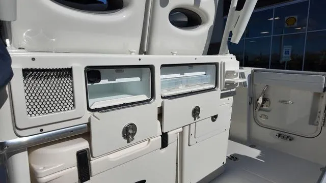 Slide: The Image of 2025 Cobia 265 CC boat interior with storage compartments and seating. - 11
