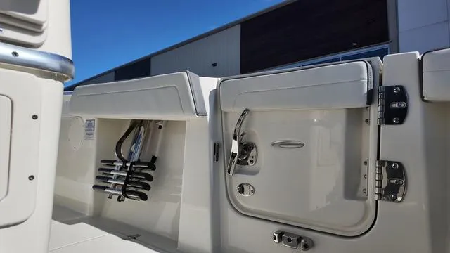 Slide: The Image of 2025 Cobia 265 CC boat interior with storage compartments and fishing rod holders. - 15