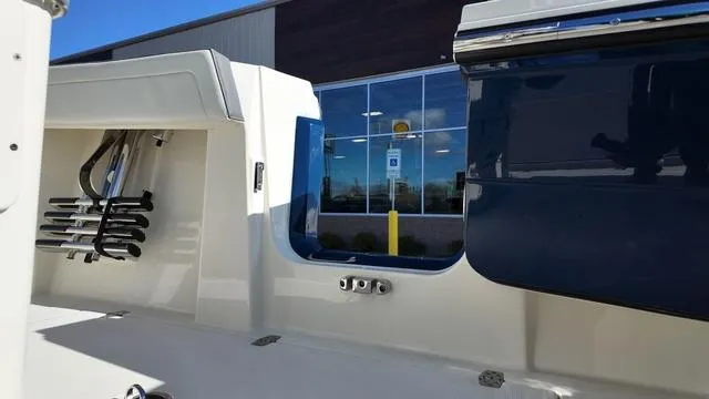 Slide: The Image of 2025 Cobia 265 CC boat interior with rod holders and sleek design. - 16