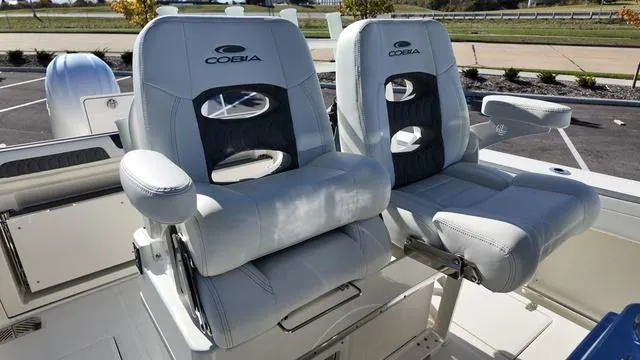 Slide: The Image of 2025 Cobia 265 CC boat seats, featuring plush white upholstery and ergonomic design. - 19