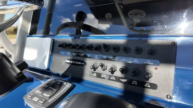 Slide: The Image of Control panel of 2025 Cobia 265 CC boat with switches and buttons. - 21