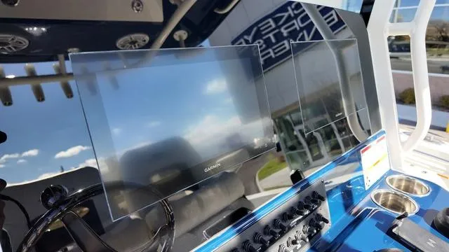 Slide: The Image of 2025 Cobia 265 CC boat dashboard with Garmin display and control panel. - 22