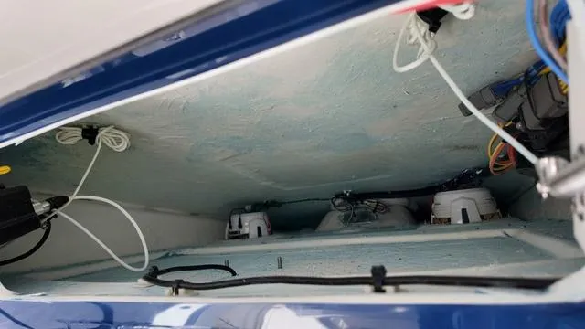 Slide: The Image of Interior view of 2025 Cobia 265 CC boat compartment with wiring and components. - 26