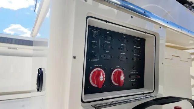 Slide: The Image of Control panel of 2025 Cobia 265 CC boat with switches and dials. - 29