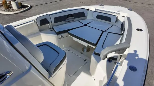 Slide: The Image of 2025 Cobia 265 CC boat interior with cushioned seating and table. - 30