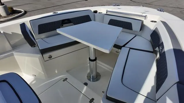 Slide: The Image of 2025 Cobia 265 CC boat interior with cushioned seating and table. - 32