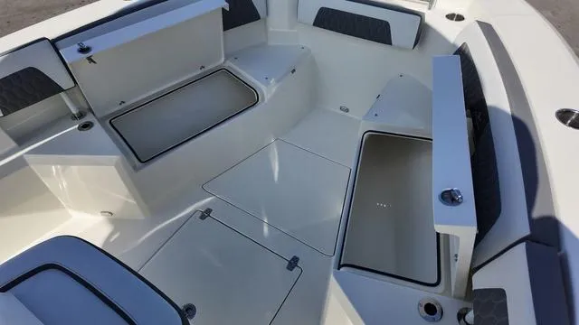Slide: The Image of 2025 Cobia 265 CC boat interior with open storage compartments and cushioned seating. - 35