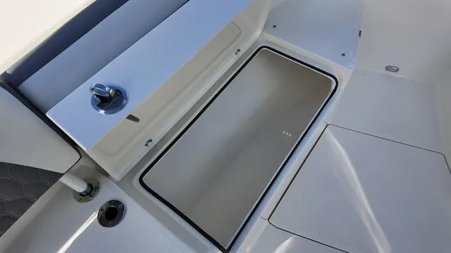 Slide: The Image of 2025 Cobia 265 CC boat storage compartment with open hatch. - 37