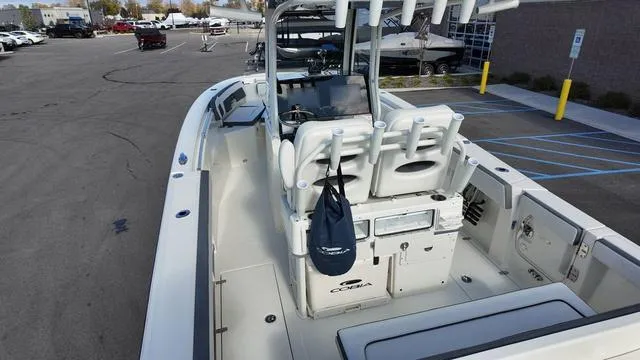 Slide: The Image of 2025 Cobia 265 CC boat with spacious deck and modern seating in a parking lot. - 4