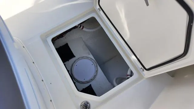 Slide: The Image of 2025 Cobia 265 CC boat storage compartment with open hatch. - 40