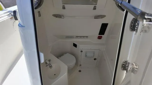 Slide: The Image of 2025 Cobia 265 CC boat interior with compact bathroom and sink. - 43