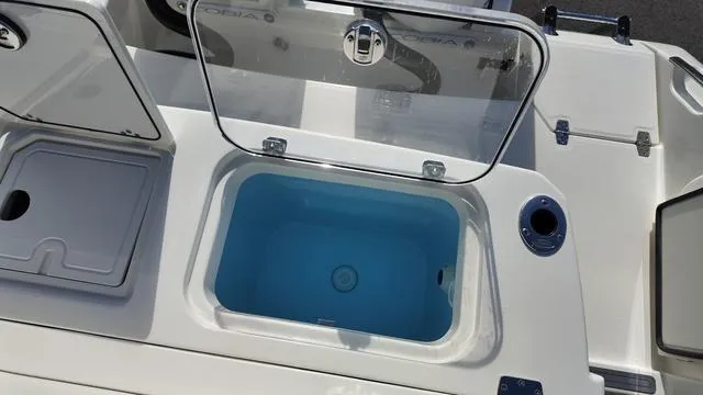 Slide: The Image of 2025 Cobia 265 CC boat livewell with open lid, showcasing interior design. - 7