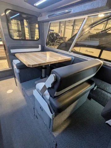 Slide: The Image of Interior of 2025 Thunder Jet Pilot 26' boat with seating and wooden table. - 24