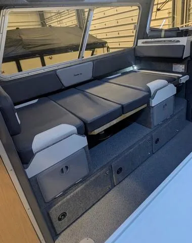 Slide: The Image of Interior of 2025 Thunder Jet Pilot 26' boat with cushioned seating and storage compartments. - 26