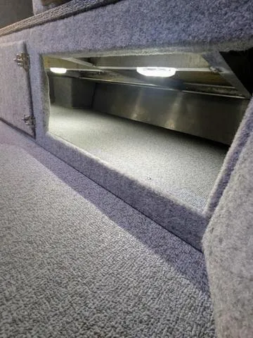 Slide: The Image of Interior storage compartment of 2025 Thunder Jet Pilot 26' boat, carpeted and illuminated. - 28