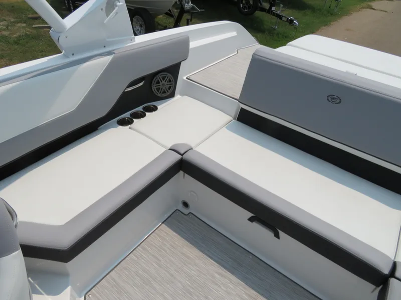 Slide: The Image of 2025 Cobalt CS23 boat interior with white and gray seating, cup holders, and speaker. - 10