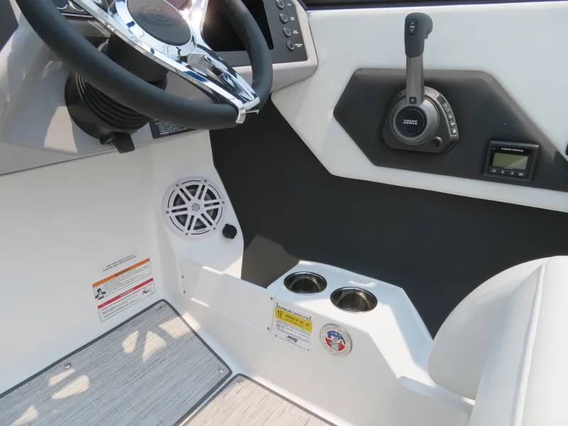 Slide: The Image of 2025 Cobalt CS23 boat interior with steering wheel, control panel, and cup holders. - 12