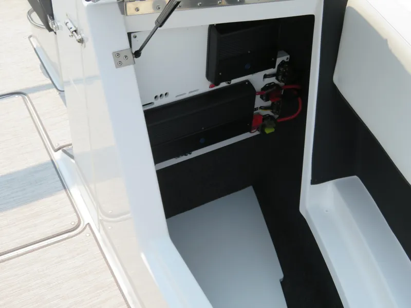 Slide: The Image of 2025 Cobalt CS23 boat interior storage compartment with electrical components. - 14