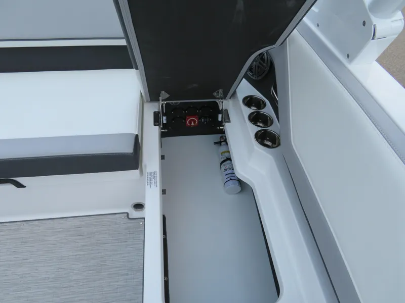 Slide: The Image of 2025 Cobalt CS22 boat interior storage compartment with open hatch and cup holders. - 12