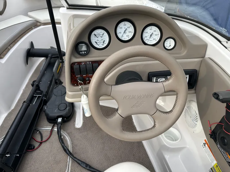 Slide: The Image of 2003 Four Winns Freedom 180F/S boat dashboard with steering wheel and instrument panel. - 13