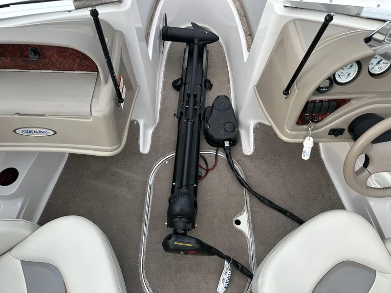 Slide: The Image of 2003 Four Winns Freedom 180F/S boat interior with trolling motor and dashboard controls. - 17