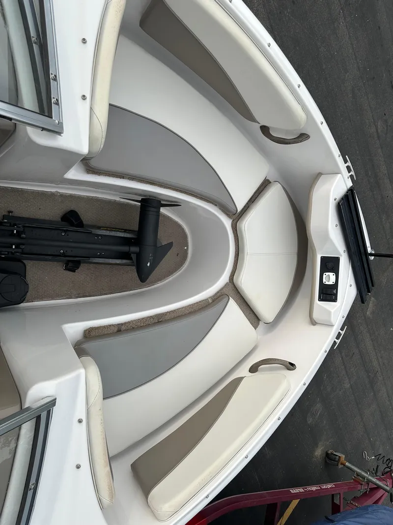 Slide: The Image of 2003 Four Winns Freedom 180F/S boat interior with cushioned seating and storage compartments. - 19