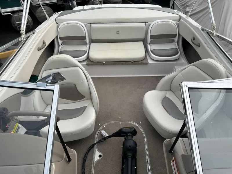 Slide: The Image of 2003 Four Winns Freedom 180F/S boat interior with beige seating and carpeted floor. - 25