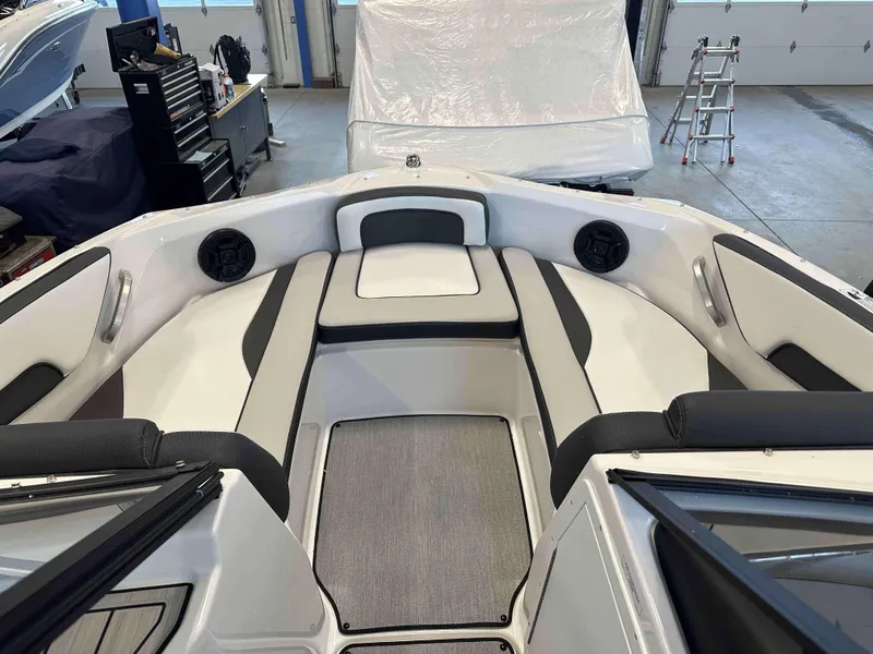 Slide: The Image of 2025 Yamaha Boats SX195 interior with sleek seating and modern design in a garage setting. - 8