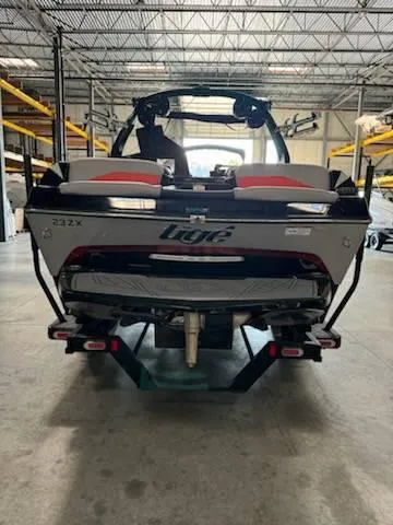 Slide: The Image of 2022 Tigé 23ZE boat in warehouse, rear view with trailer. - 17