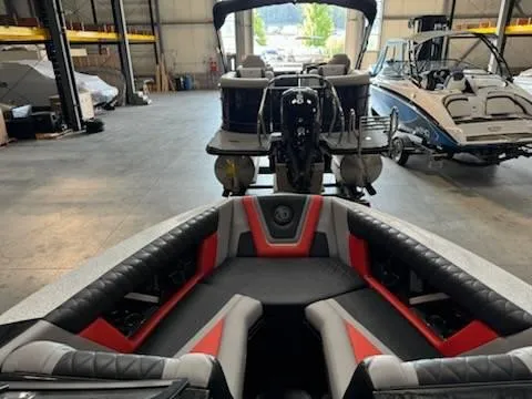 Slide: The Image of 2022 Tigé 23ZE boat interior in a showroom with other boats. - 18