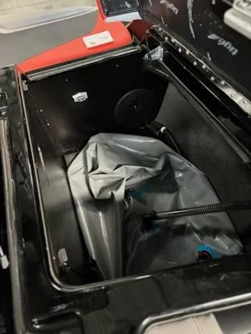 Slide: The Image of 2022 Tigé 23ZE boat storage compartment with gray bag and hose. - 22