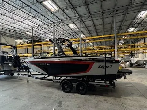 Slide: The Image of 2022 Tigé 23ZE boat in warehouse, sleek design, black and red accents. - 3