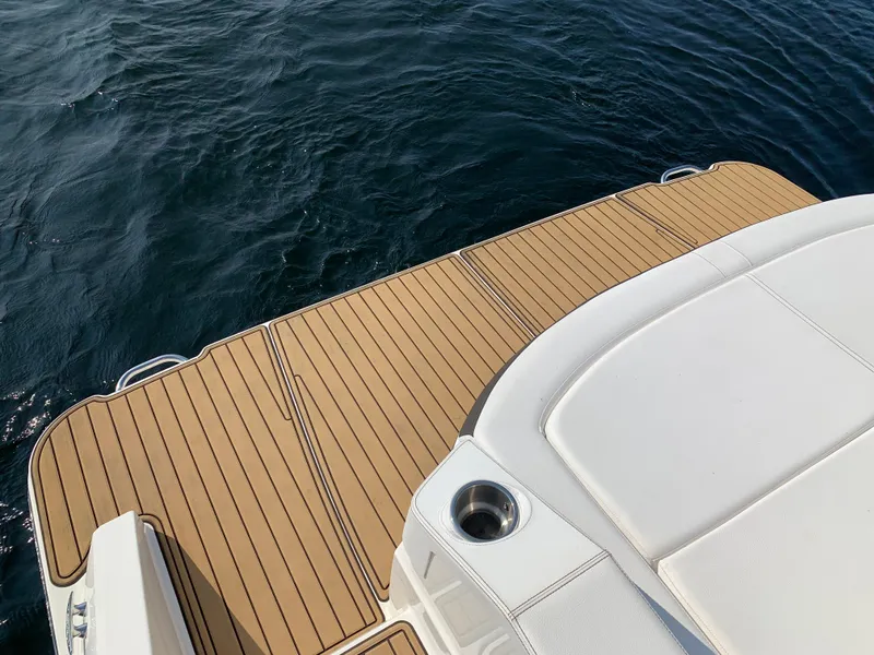 Slide: The Image of 2019 Sea Ray SLX 310 boat deck with teak flooring on water. - 14