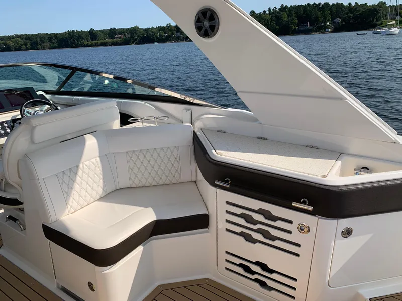 Slide: The Image of 2019 Sea Ray SLX 310 boat interior with white seating and lake view. - 16
