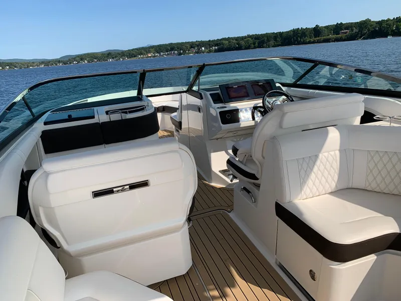 Slide: The Image of 2019 Sea Ray SLX 310 boat interior with luxurious seating on a sunny day. - 17