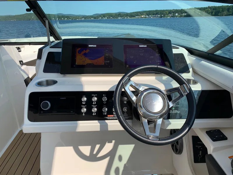 Slide: The Image of 2019 Sea Ray SLX 310 helm with modern controls and dual Simrad displays. - 19