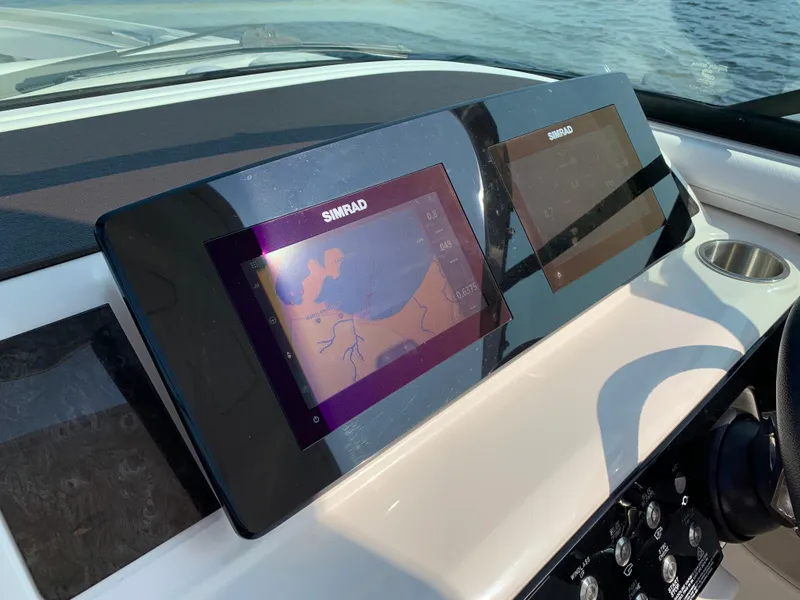 Slide: The Image of 2019 Sea Ray SLX 310 dashboard with dual Simrad navigation displays. - 21