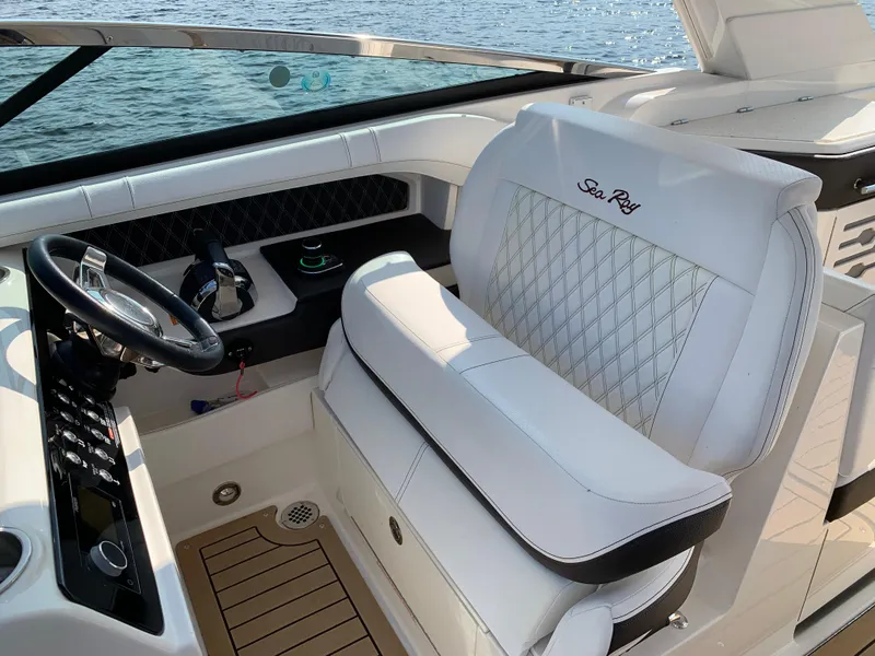 Slide: The Image of 2019 Sea Ray SLX 310 boat interior with luxurious white seating and steering wheel. - 22