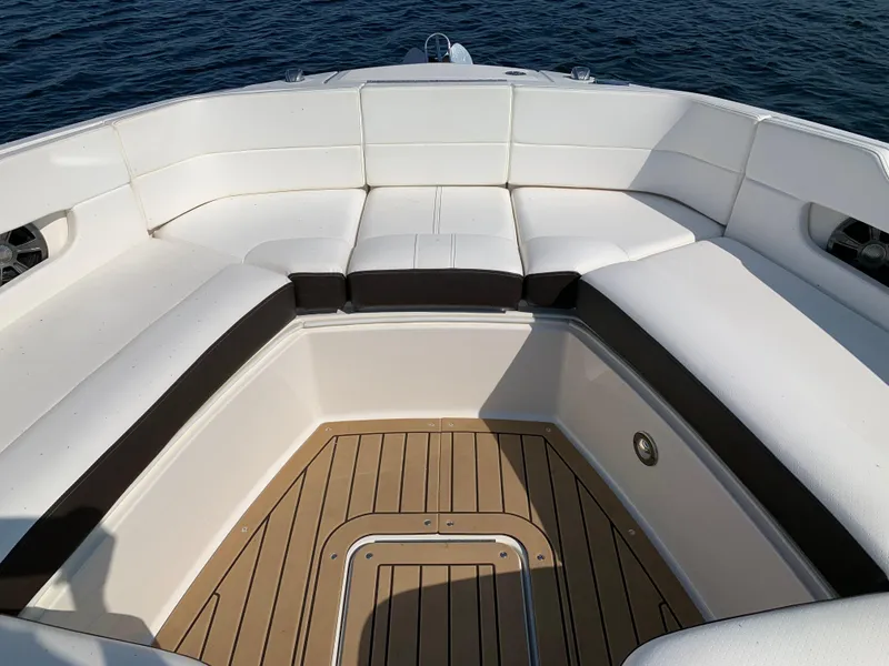 Slide: The Image of 2019 Sea Ray SLX 310 boat interior with white seating and teak flooring. - 26