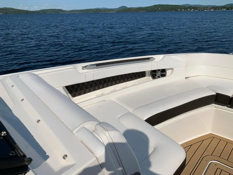 Slide: The Image of 2019 Sea Ray SLX 310 boat interior with white seating on a lake. - 27