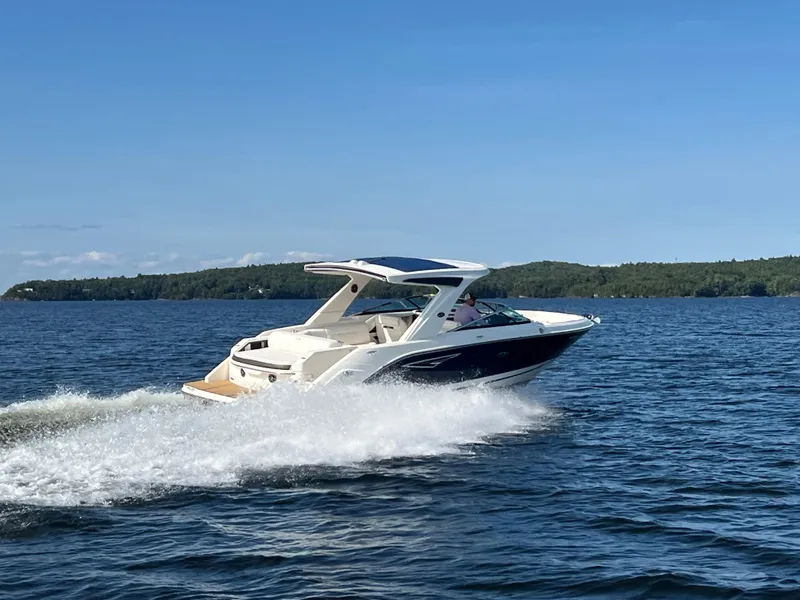 Slide: The Image of 2019 Sea Ray SLX 310 cruising on a lake with scenic background. - 3