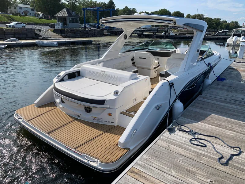 Slide: The Image of 2019 Sea Ray SLX 310 boat docked at marina, featuring sleek design and spacious seating. - 31
