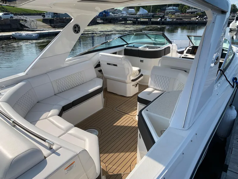 Slide: The Image of 2019 Sea Ray SLX 310 boat interior with white seating and wood flooring. - 33