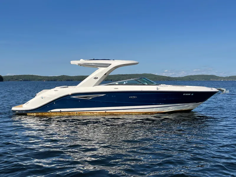 Slide: The Image of 2019 Sea Ray SLX 310 boat on a calm lake under clear blue skies. - 37