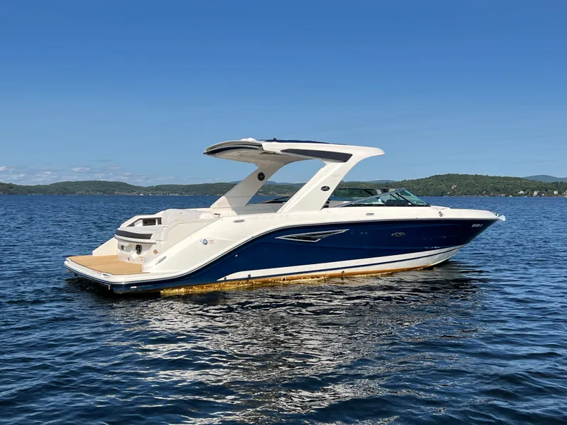 Slide: The Image of 2019 Sea Ray SLX 310 boat on a calm lake under clear blue skies. - 39